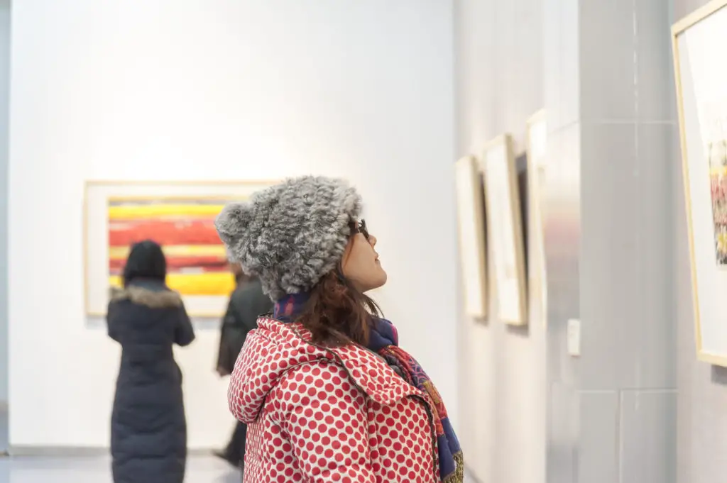 Woman dressed in polka dot coat at a private art show.